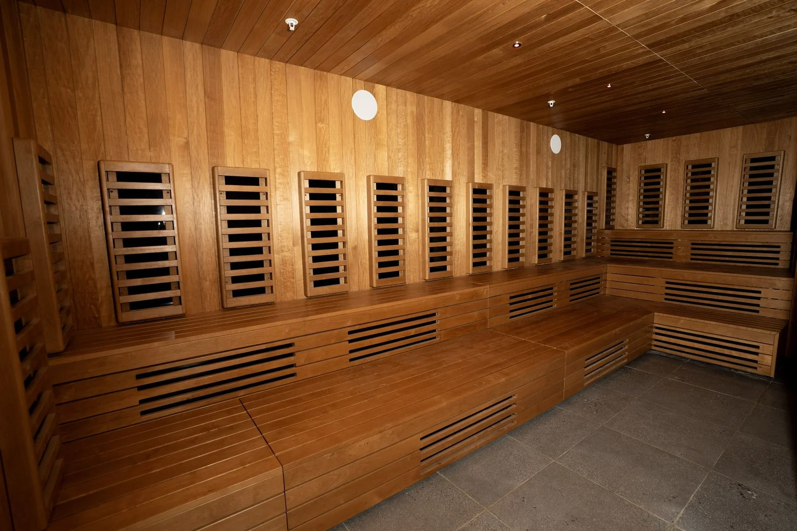 Bathhouse Atlantic infrared room with timber benches and individual infrared panels along the walls