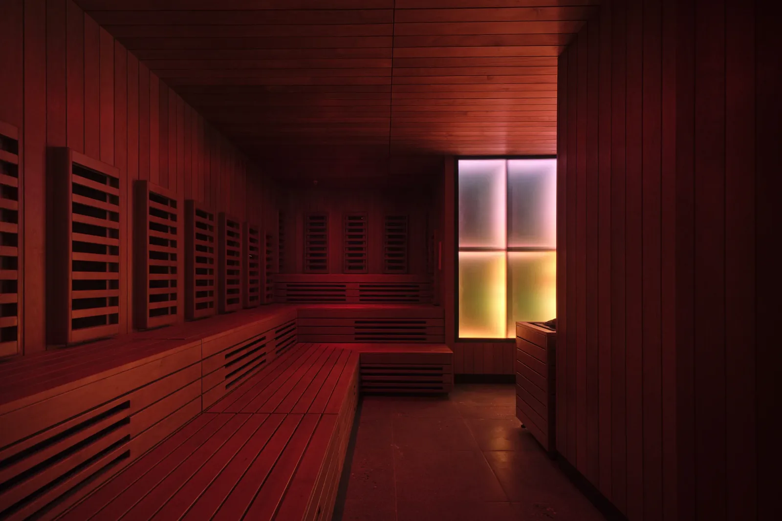 Bathhouse Atlantic infrared room with timber benches, wall panels and illuminated frosted glass